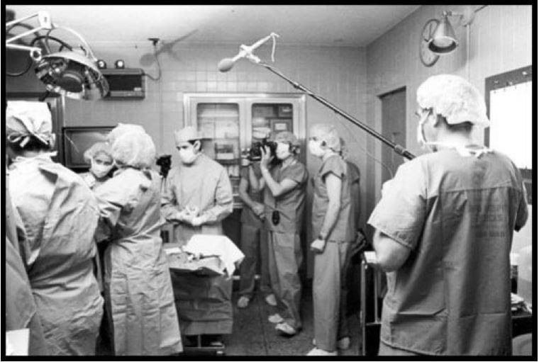 مقدمو الخدمات الطبية وأعضاء وسائل الإعلام يصورون فيلمًا وثائقيًا عن ولادة كار يقفون في غرفة العمليات.